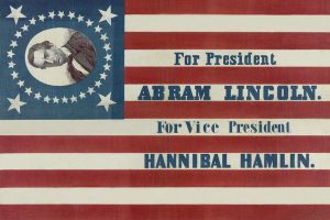 UNITED STATES - CIRCA 1860: campaign banner for Republican presidential candidate Abraham Lincoln and running mate Hannibal Hamlin. Lincoln's first name is given here as "Abram." The banner consists of a thirty-three star American flag pattern printed on cloth. In the corner a bust portrait of Lincoln, encircled by stars, appears on a blue field. (Photo by Buyenlarge/Getty Images)